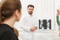 Doctor showing results of X-ray examination to his patient and explains the cause of her pain in medical office. Patient Royalty Free Stock Photo