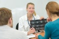 Doctor showing scan results to young couple Royalty Free Stock Photo