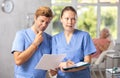 Doctor showing something in his folder to his colleague. Royalty Free Stock Photo