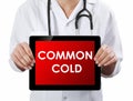 Doctor showing tablet with COMMON COLD text Royalty Free Stock Photo