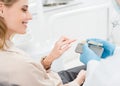 Doctor showing tooth implants to female patient in modern