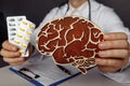 Doctor is showing wooden brain and pills. Importance of early diagnosis and treatment concept