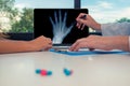 Doctor showing a x-ray of a left hand on a laptop to a woman patient. Osteoarthritis concept Royalty Free Stock Photo