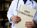 Doctor shows Annual open enrollment stack of papers. Royalty Free Stock Photo