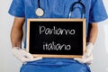 Doctor shows information on blackboard: we speak italian. Medical concept