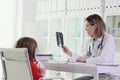 Doctor shows X-ray image of lungs to girl sitting at table Royalty Free Stock Photo