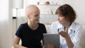 Doctor and sick female cancer patient discuss results on pad Royalty Free Stock Photo