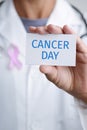 Doctor and signboard with the text cancer day