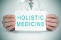 Doctor with a signboard with the text holistic medicine