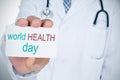 Doctor with signboard with text world health day