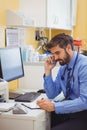 Doctor sitting at his desk and talking on phone Royalty Free Stock Photo