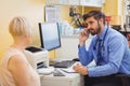 Doctor sitting at his desk and talking on phone Royalty Free Stock Photo