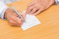 Doctor sitting at his desk writing on prescription pad Royalty Free Stock Photo