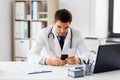 Doctor with smartphone at medical office in clinic