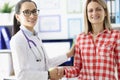 Doctor smiling and shaking patients hand in clinic