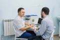 Doctor smiling and talking to patient in office Royalty Free Stock Photo