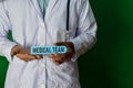 Doctor standing on Green background. Hold the Medical Team paper text Royalty Free Stock Photo