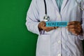 Doctor standing on Green background. Hold the Multiple Sclerosis paper text. Royalty Free Stock Photo