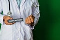 Doctor standing on Green background. Selective focus in hand. healthy and happy paper text.