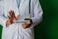 Doctor standing on Green background. Selective focus in hand. High Colesterol paper text. Medical and healthcare concept Royalty Free Stock Photo