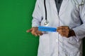 A doctor standing, Hold the Prevention Cure paper text on Green background. Medical and healthcare concept