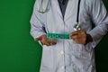 A doctor standing, Hold the Psychosis paper text on Green background. Medical and healthcare concept