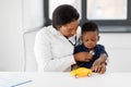 Doctor with stethoscope and baby patient at clinic Royalty Free Stock Photo
