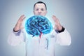 Doctor with stethoscope and brains on the hands. gray background. High resolution. Royalty Free Stock Photo