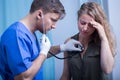 Doctor with stethoscope diagnosing patient