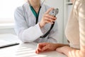 Doctor with a stethoscope in the hand. Physician examines her female patient.