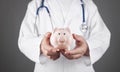 Doctor with stethoscope holding piggy bank Royalty Free Stock Photo