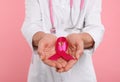 Doctor with stethoscope holding pink ribbon on color background, closeup. Breast cancer awareness Royalty Free Stock Photo