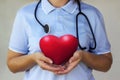 Doctor with stethoscope holding a red heart in the hands closeup. Royalty Free Stock Photo