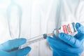 Doctor with stethoscope on the neck and hand in medical glove holding syringe and vial of the coronavirus vaccine for injection. p Royalty Free Stock Photo