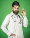 Doctor with stethoscope on neck in white medical robe showing okay gesture. Medicine and healthcare. Royalty Free Stock Photo