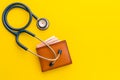 Doctor stethoscope and the new leather brown men wallet on yellow background. Budget for health check or money and financial