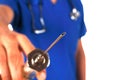 Doctor with stethoscope shows a big syringe isolated on white Royalty Free Stock Photo