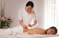 The doctor sticks needles into the woman`s body on the acupuncture Royalty Free Stock Photo