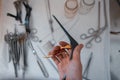 Doctor surgeon holds in his hand a black medical clip for performing an operation against the background of other metal