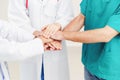 Doctor, surgeon and nurse join hands together