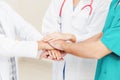 Doctor, surgeon and nurse join hands together