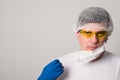 Doctor in a surgical mask, gloves and glasses. Young man in a medical mask