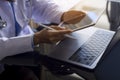 Doctor using modern digital tablet, work on laptop computer on office desk at workplace. Online medical, e health or telehealth c
