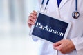 Doctor with tablet with parkinson message