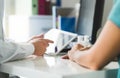 Doctor with tablet and patient having a discussion, meeting and appointment in hospital office room.