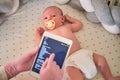 Doctor takes notes on a digital tablet on the treatment of a newborn baby