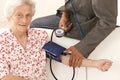 Doctor taking blood pressure to patient at home Royalty Free Stock Photo