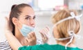 Doctor taking coronavirus test by a swab on a female patient with a face mask