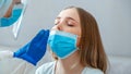 Doctor taking nasopharyngeal culture, PCR test to woman patient. Nurse take saliva sample through nose with cotton swab to check Royalty Free Stock Photo