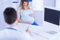 Doctor taking notes while listening to pregnant patient Royalty Free Stock Photo